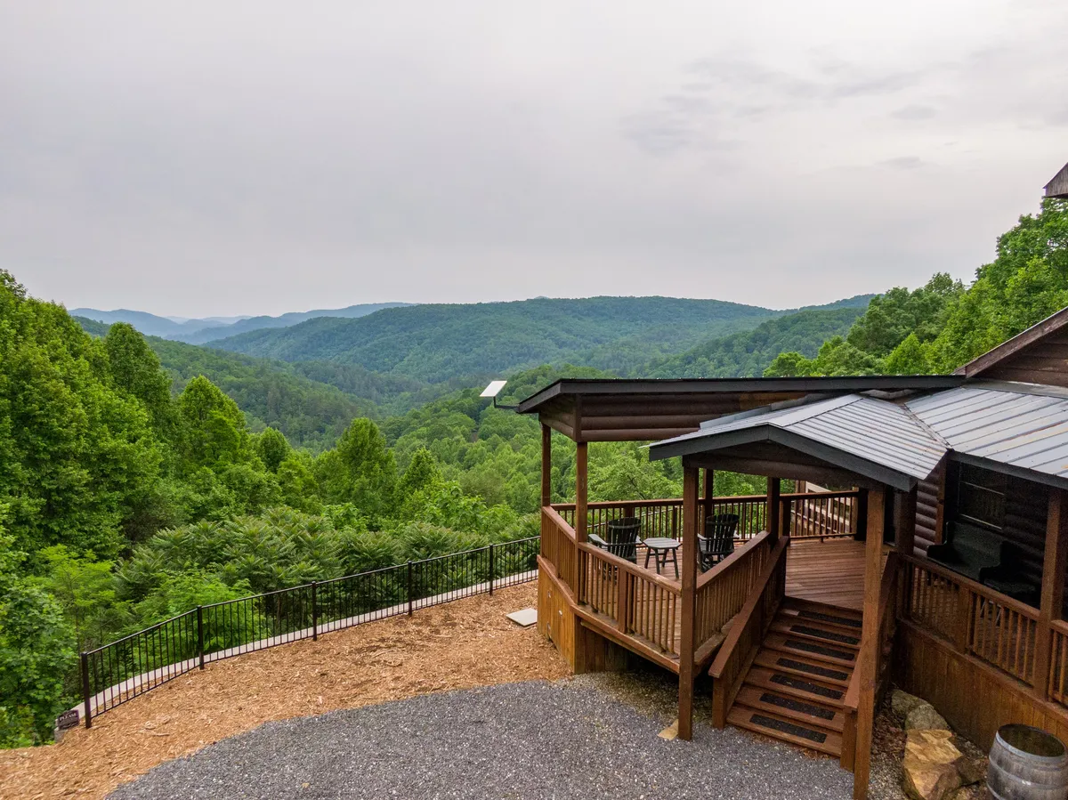 The hero image showcases a spacious deck with inviting seating, framed by a rustic wooden railing and set against a backdrop of sweeping, long-range mountain views. The tranquil scene suggests the ideal spot for relaxing, socializing, or soaking in the beauty of nature, with the deck positioned to fully capture the region's stunning vistas.