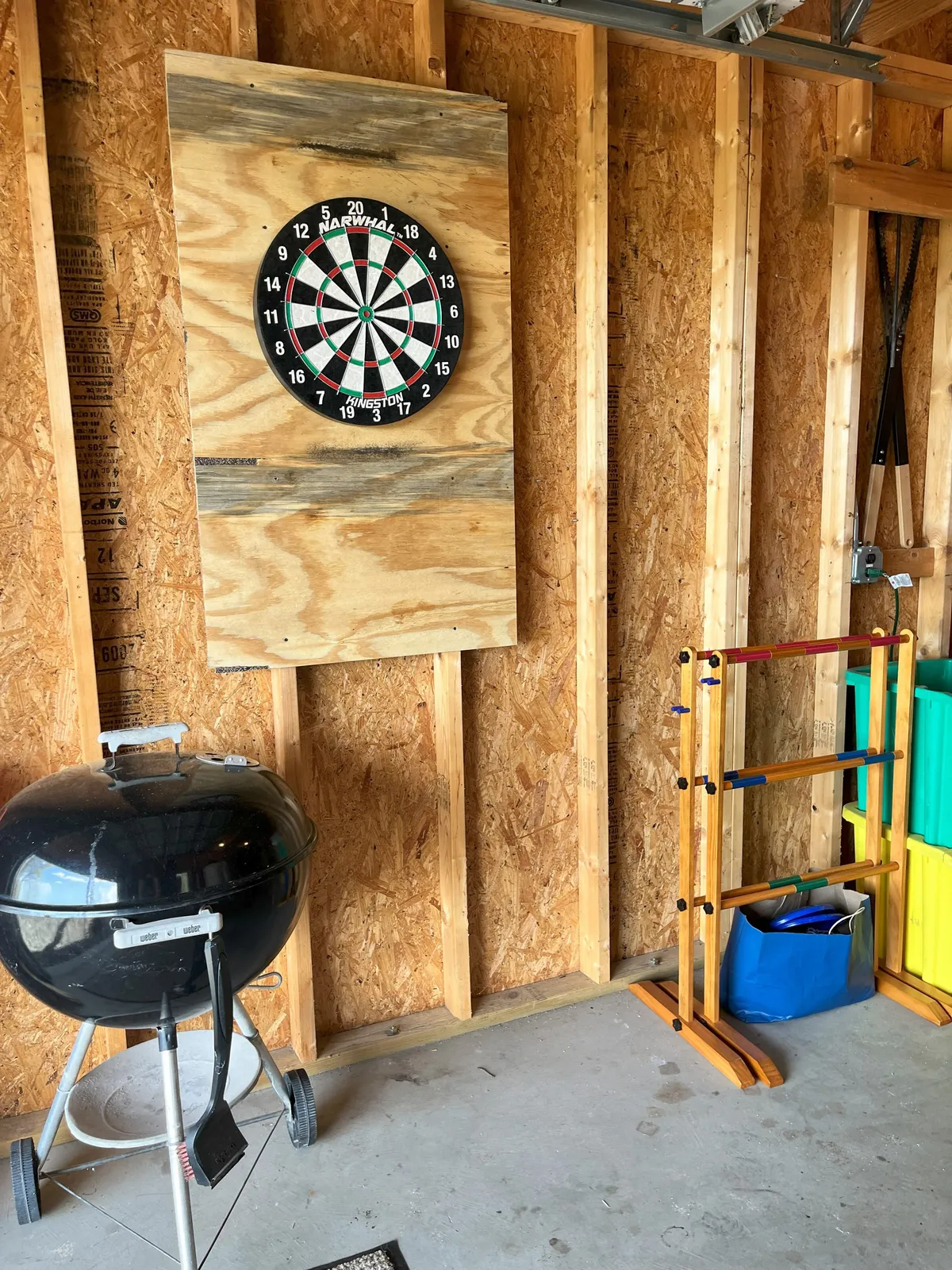 This interior image captures a lively area featuring a dartboard, a games rack, and a grill, all set in a playful, relaxed environment that encourages social interaction and fun. The elements suggest a space ideal for classic games and friendly competitions.